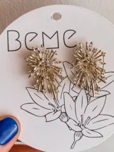 Par de caravanas doradas con forma de estrella con incrustaciones de strass.