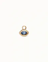 Charm para piercing con forma de ojo, engaste dorado y cristal Swarovski facetado color azul claro (light sapphire). Incluye una argolla superior para sujetar.
