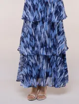 Vestido maxi azul de gasa liviana con estampado abstracto, escote halter fruncido con lazo ajustable, diseño sin mangas, fino cinturón a tono y falda larga con volados escalonados.