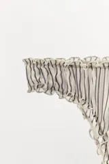 Braguita de tiro medio con estampado de rayas verticales en blanco y negro, confeccionada en viscosa 100%. Presenta cintura elástica y acabados en ondas.