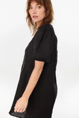 Vestido corto negro de lino italiano, con escote en V, mangas cortas abullonadas y cierre frontal de botones con cintura entallada y tablas.