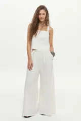 Pantalón palazzo de lino color blanco, de corte amplio con aberturas laterales, cintura elastizada con lazo ajustable y bolsillos.