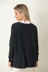 Buzo verde oliva de punto fino con detalle de líneas diagonales en el mismo material y cuello camisero blanco.