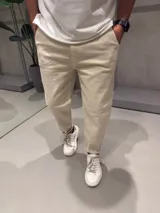 Jean de corte slouchy en color beige, confeccionado en denim de algodón. Presenta un diseño de tiro medio con ajuste holgado en la cadera y muslos, estrechándose hacia los tobillos.