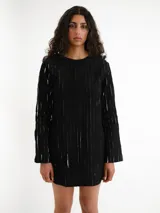 Vestido corto negro con textura de rayas verticales claras, escote redondo y mangas largas.