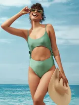 Malla enteriza color verde con diseño cut-out en la cintura y laterales con lazos ajustables. Presenta breteles finos y escote redondo.