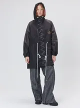 Campera tipo piloto con capucha, cierre frontal con botones y detalle de costuras en zigzag. Presenta cordones ajustables en la cintura y capucha, puños elásticos y logo bordado en el pecho.