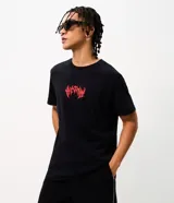 Remera negra de algodón con cuello redondo y mangas cortas, de corte comfort. Presenta una gran estampa en la espalda con una ilustración de Batman y tipografía en tonos rojos y blancos.