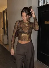 Top de microtul verde con estampado abstracto, manga larga y cuello redondo. Presenta terminaciones con dobladillo ondulado en el cuello, los puños y el ruedo.