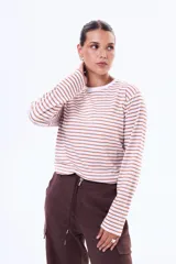 Remera de manga larga con diseño de rayas horizontales en color rojo y blanco, confeccionada en algodón, con cuello redondo y corte clásico.