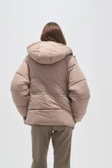 Campera puffer de corte holgado, color beige, con capucha desmontable, cierre frontal y puños elásticos.