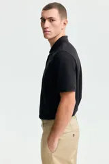 Remera polo de manga corta en piqué de algodón con cuello y tapeta de botones. Corte estándar para una silueta clásica y cómoda.