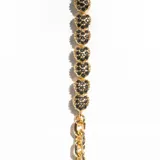 Pulsera dorada de eslabones con corazones cubiertos de cristales negros.