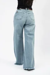 Jean de corte campana con tiro medio, confeccionado en denim con elastano. Presenta un lavado claro y ruedo deshilachado.