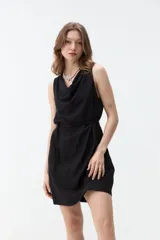 Vestido corto negro sin mangas, con escote drapeado y lazo fino para ajustar en la cintura.