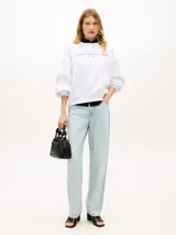 Buzo de cuello redondo Tommy Hilfiger color blanco, de manga larga, confeccionado en mezcla de algodón y poliéster reciclado, con el logo de la marca bordado en el pecho.