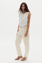 Pantalón de jean color blanco marfil, con tiro medio, corte barrel relajado y bolsillos frontales y traseros.