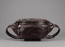 Riñonera de cuero color negro, con múltiples compartimentos con cierre metálico, detalles de tachas en los laterales y correa regulable.