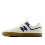 Championes New Balance Numeric 574, modelo de skate en color beige con detalles en azul y suela de goma color caramelo. Confeccionados en gamuza y malla, presentan el logo N característico en los laterales.