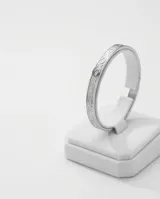 Esclava rígida de acero inoxidable con diseño de eslabones circulares grabados en toda su superficie.