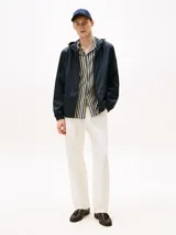 Campera con capucha de poliéster reciclado, color azul marino, con cierre frontal de cremallera. Presenta detalles en los colores de la marca (RWB) y un logo engomado de Tommy Hilfiger en la manga.