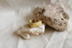 Anillo sello dorado de bronce con forma cuadrada.