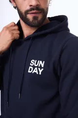 Buzo con capucha y bolsillo canguro, confeccionado en felpa azul marino. Presenta un estampado gráfico en la espalda que ilustra montañas con un sol y el texto 'Sunday Day, Our Leisure Day'.