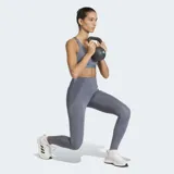 Top deportivo Adidas de soporte medio, color gris, con diseño racer-back y logo de la marca estampado en el frente. Confeccionado en tejido técnico transpirable con tecnología Climacool y almohadillas removibles.