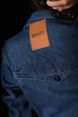 Mono largo de denim azul, con mangas largas, bolsillos delanteros y traseros, y avíos metálicos. Presenta una badana de PU en la espalda.