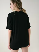 Remera de manga corta color negro, de corte oversize y escote redondo, confeccionada en viscosa suave y liviana.
