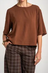 Blusa marrón de corte holgado, con escote redondo y mangas cortas amplias.