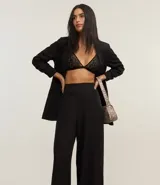 Pantalón pantalona femenina confeccionada en crepé, con cintura ancha, cremallera lateral y pences en la parte trasera.