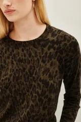 Sweater de punto con estampado animal print en tonos verde oliva y negro, de cuello redondo y manga larga con puños acanalados.