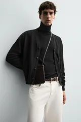 Jersey negro de punto fino con cuello alto y manga larga.