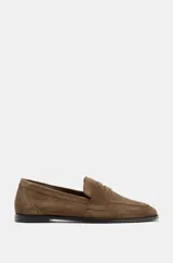 Mocasín plano de mujer confeccionado en serraje, con diseño de antifaz en el empeine, costuras visibles y punta redonda.