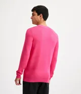 Suéter de viscosa texturizada color fucsia, de corte slim, cuello redondo y mangas largas con puños ajustados.