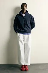 Sudadera polo de corte regular, confeccionada en tejido técnico interlock de algodón con elasticidad. Presenta cuello solapa, cierre frontal de cremallera y manga larga con puños acabados en rib.