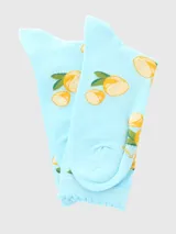 Calcetín de largo medio color celeste con estampado de limones amarillos y hojas verdes. Presenta un puño superior con borde festoneado.