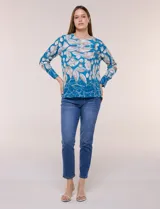 Blusa de silueta holgada y corte recto con caída fluida, escote redondo y mangas largas con puños anchos estructurados, con estampado floral en tonos pasteles sobre fondo blanco.
