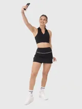 Falda deportiva negra con diseño de tiro alto y ribete blanco en la cintura. Incluye calza interna con bolsillo incorporado para mayor funcionalidad durante la actividad física.