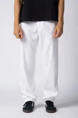 Pantalón blanco de lino y algodón, de calce suelto y tiro medio/alto con cintura elastizada y cordón regulable. Presenta bolsillos laterales amplios y un bolsillo trasero con tapa.