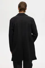 Abrigo de corte clásico confeccionado en tejido afieltrado con mezcla de lana. Presenta solapas de muesca, cierre frontal con tres botones y bolsillos laterales insertados al bies. Diseño de silueta estructurada con mangas forradas.
