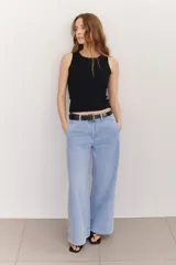 Pantalón jean negro de corte ancho y tiro alto, con pinzas delanteras y pespuntes laterales.