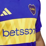 Camiseta de fútbol Adidas del Club Atlético Boca Juniors, modelo Home 24/25. Diseño azul con franja horizontal amarilla con el sponsor Betsson, detalles en amarillo en cuello y hombros, escudo del club y logo de Adidas.