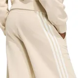 Pantalón de jogging Adidas de corte ancho, color beige, con cintura elástica, bolsillos laterales y las clásicas tres tiras blancas a los lados. Cuenta con el logo de la marca bordado en la pierna izquierda.