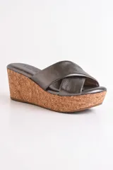 Sandalia color beige con plataforma de corcho y tiras cruzadas de cuero.