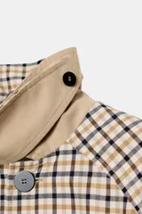 Trench reversible de Zara Woman Collection con diseño de cuadros en tonos beige, negro y tostado. Cuenta con cuello de solapa, cierre frontal con botones oscuros y bolsillos delanteros diagonales.