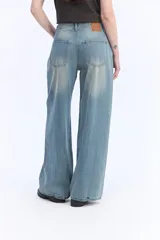 Jean wide leg de tiro medio, color celeste con lavado efecto vintage, piernas amplias y caída suelta, sin pretina y con cordón ajustable en la cintura.