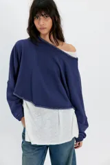 Buzo liviano azul de mezcla de algodón, de calce corto y holgado, con escote barco, mangas largas, hombros caídos y costuras deshilachadas.