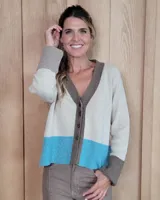 Cardigan de punto con escote en V y cierre frontal de botones. Presenta un diseño tricolor con cuerpo en beige, franja inferior en turquesa y detalles en puños y tapeta de botones en color marrón.